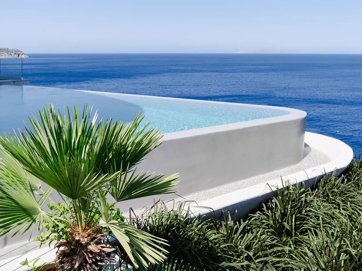 Curved heated infinity pool merging with the Aegean horizon