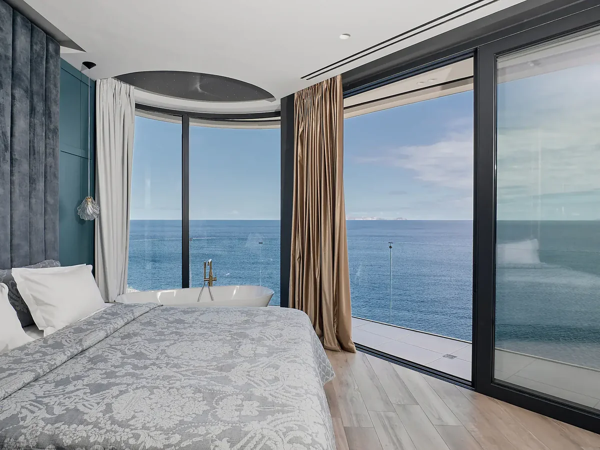 Master bedroom suite with panoramic sea view and freestanding bathtub
